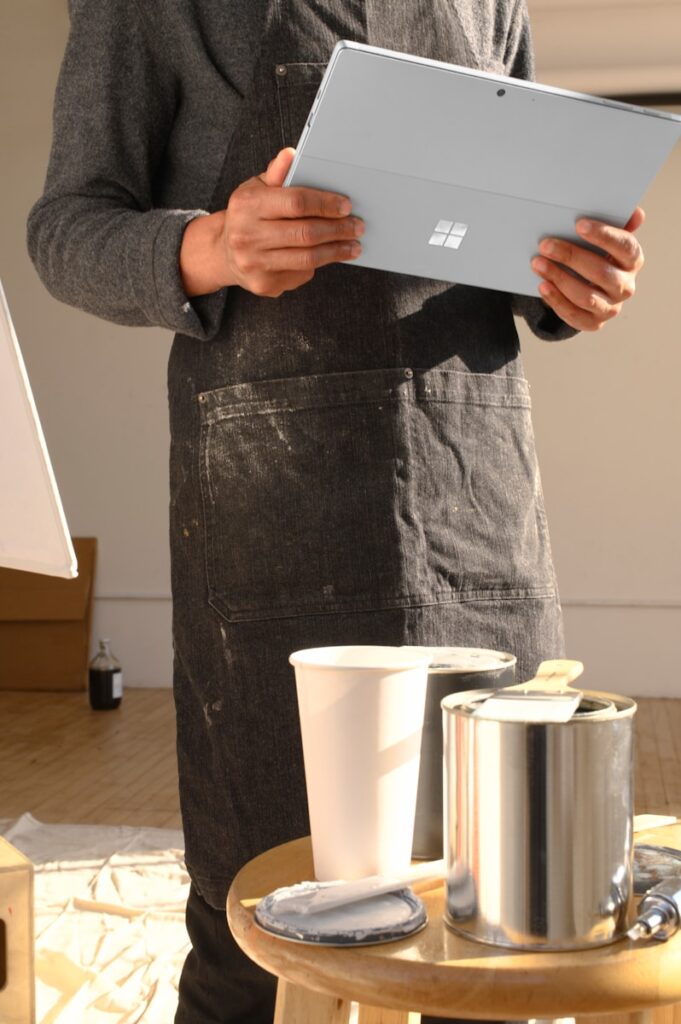 a man in an apron is holding a tablet